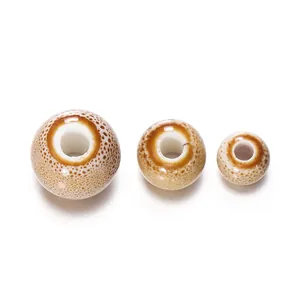 Detail showing three sizes of speckled brown ceramic beads for DIY jewelry crafts.
