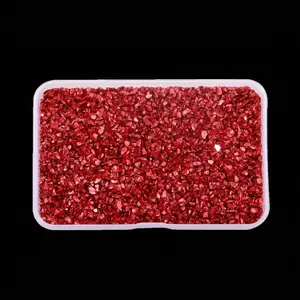 Close-up macro detail of irregular bright red crushed glass stones for nail art DIY crafts
