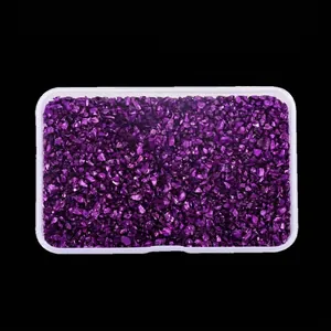 Top view of shiny irregular purple crushed glass stones stored in a clear plastic box