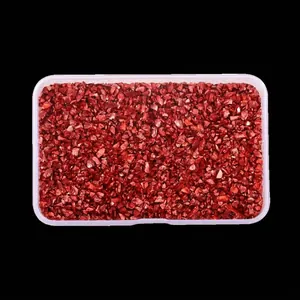 Close-up of irregular high-gloss red glass crushed stones in a storage box for DIY