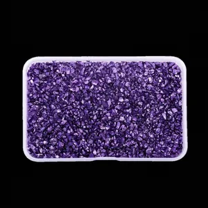 Close-up detail of high-shine irregular purple glass crushed stones in a clear box