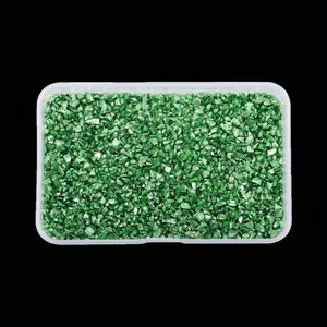Detailed view of irregular emerald green high-bright crushed glass stones in a box