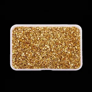 High-angle macro view of irregular golden metallic crushed glass stones for DIY crafts