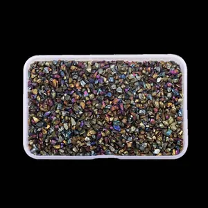 Close-up of irregular iridescent glass crushed stones for DIY nail art in a box.