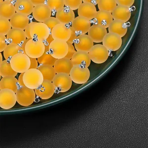 Macro view of yellow frosted acrylic round bead pendants for DIY jewelry craft making