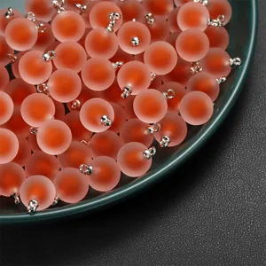 Close-up of frosted acrylic bead-in-bead pendants for DIY jewelry making.