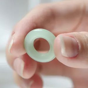 Gros plan macro d'une bague donut en verre imitation jade vert clair pour bijoux DIY