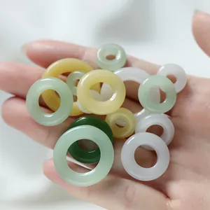 Détail macro de divers anneaux en verre imitation jade colorés pour accessoires de bijoux DIY