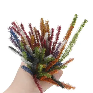 Hand holding a bunch of colorful glitter pipe cleaners for DIY bouquet craft projects