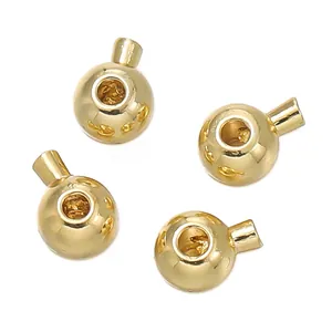 Macro detail view of four 18K gold-plated metallic end beads for DIY jewelry making