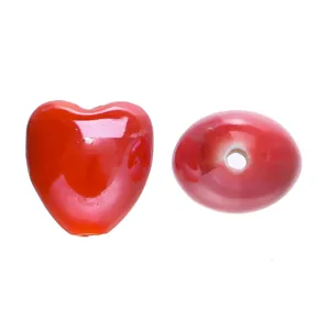 Close-up detail of glossy red heart-shaped candy color ceramic beads for DIY jewelry making.