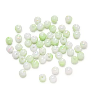 Primo piano di perle tonde in acrilico sfumato verde chiaro per creazione gioielli