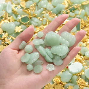 Handheld close-up of light green imitation jade charms for DIY jewelry making