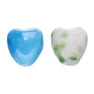 Detailed view of heart-shaped ceramic beads in sky blue and green speckled white.