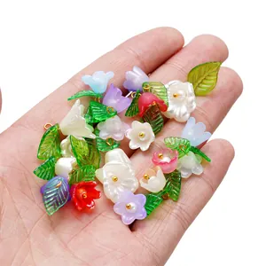 Colorful acrylic flower and leaf pendants held in hand for DIY jewelry making