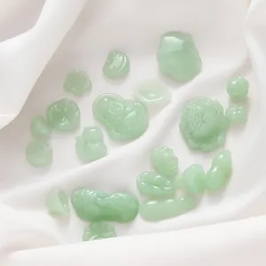 Detailed view of assorted green faux jade glass charms for DIY jewelry making