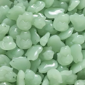 Macro view of light green glazed fox-shaped pendants for DIY jewelry making accessories