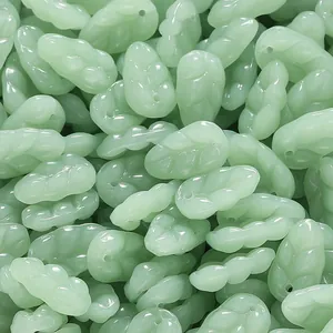 Macro view of green imitation jade glass beads in a leaf shape for DIY jewelry making.