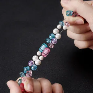 Gros plan sur un fil de perles élastique transparent montrant sa grande souplesse