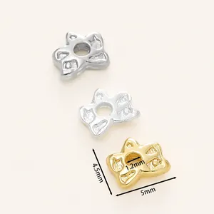 Dettaglio macro di perline distanziatrici a clessidra placcate oro 18K
