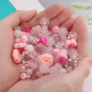 Primo piano di una manciata di perline fai-da-te rosa e bianche per creare gioielli