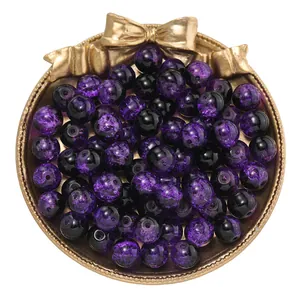 Primer plano de cuentas de vidrio craquelado moradas y negras de 10mm para joyería.