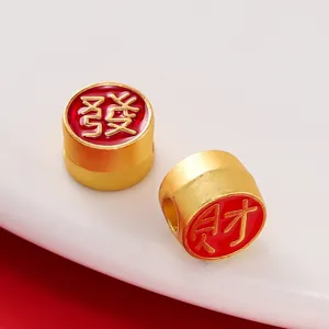 Vue macro détaillée de perles plaquées or avec émail rouge et symboles de richesse