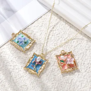 Detailed view of vintage alloy photo frame pendants with delicate enamel floral designs