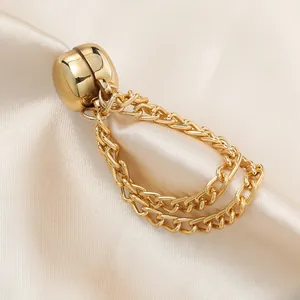Detailaufnahme eines goldenen Magnetclips mit Kette zur Kleidungsanpassung und Deko