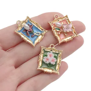 Close-up of vintage floral photo frame charms with enamel and faux pearl details