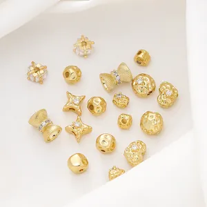 Vista dettagliata di perline per gioielli fai-da-te placcate oro 18K in varie forme su tessuto