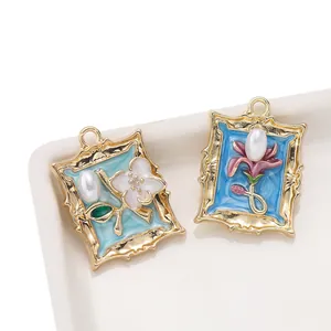 Detailed view of vintage gold-toned frame pendants with enamel flower motifs and pearls