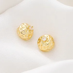 Macro dettaglio di perline distanziatrici placcate in oro 18K con pietra di zircone.