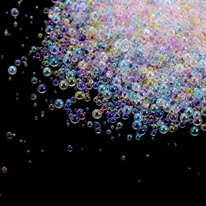 Close-up view of iridescent transparent bubble glass beads for DIY nail art designs.
