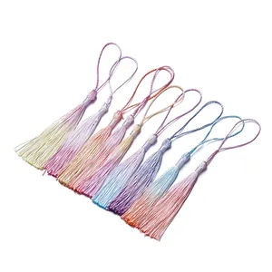 Fila di delicati mini nappe sfumate in colori pastello per gioielli fai-da-te e segnalibri.