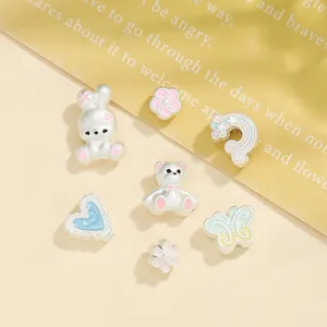 Dettaglio di ciondoli DIY in argento opaco con graziose forme in smalto pastello per gioielli.