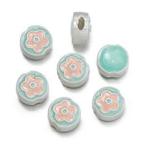 Close-up of matte silver flower beads with mint green and pink enamel for DIY jewelry