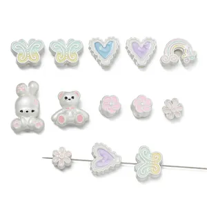 Varietà di ciondoli in smalto pastello per bracciali fai-da-te con forme a cuore e farfalla