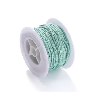 Detailed view of mint green non-elastic braiding cord on a white plastic spool