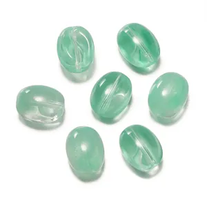 Vue macro de perles en verre vert clair en forme de grain de café pour bijoux DIY