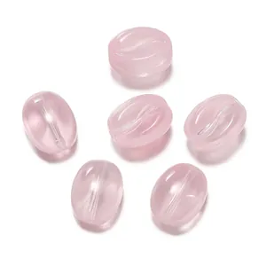 Vue détaillée de perles de verre translucides roses en forme de grain de café pour bijoux.