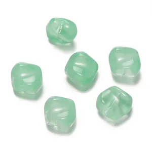 Détail macro de perles cubes en verre vert translucide pour bijoux DIY.
