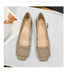 Detailed view of khaki patent leather square-toe flats featuring an iconic buckle detail.