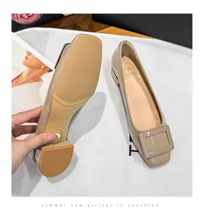 Detail view showing the non-slip sole and interior of beige patent leather pumps
