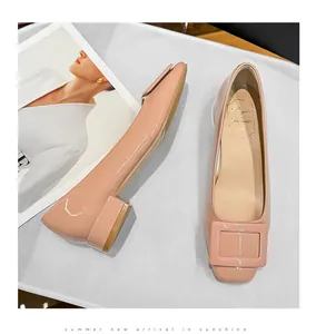 Pink patent leather low-heel shoes featuring a classic square buckle and square toe design