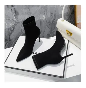 Detaillierte Nahaufnahme von eleganten schwarzen spitzen Stiletto-Socken-Stiefeln auf Weiß