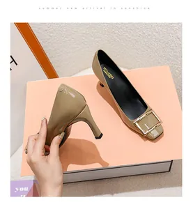 Close-up of elephant gray square buckle pumps with thin heels and patent finish