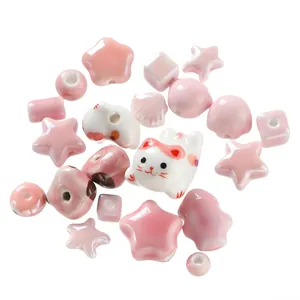 Macro detail of pink and white ceramic beads in cat and star shapes for DIY jewelry
