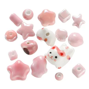 Detailed macro shot of assorted pink and white ceramic cat and star beads