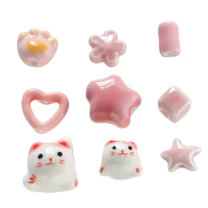 Detailed view of assorted pink ceramic beads including lucky cat and heart shapes
